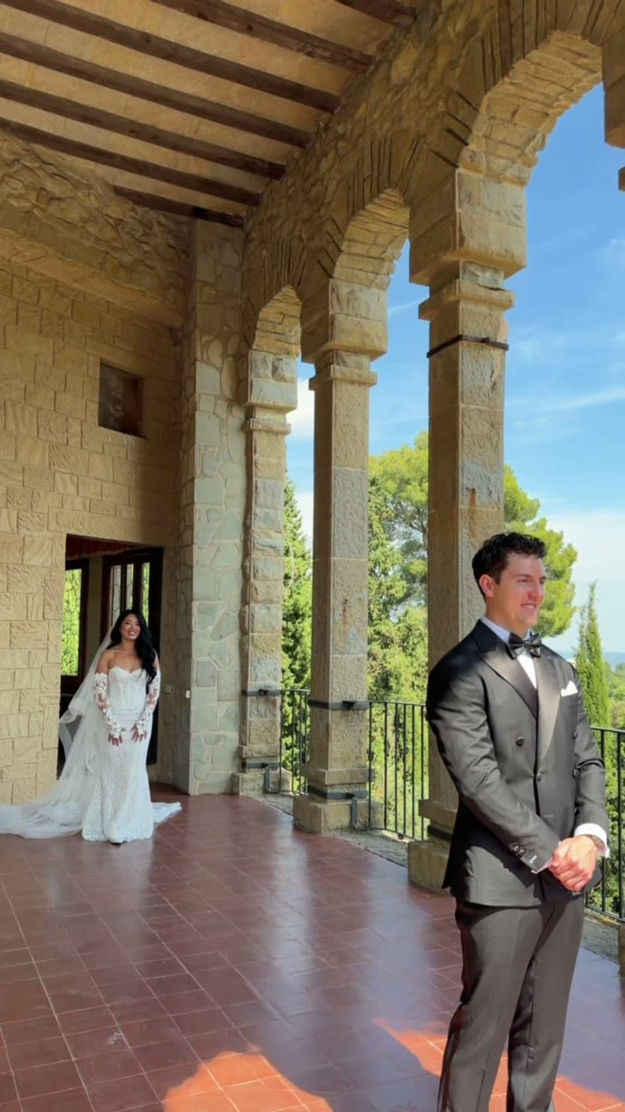 A destination wedding couple beneath stone arches