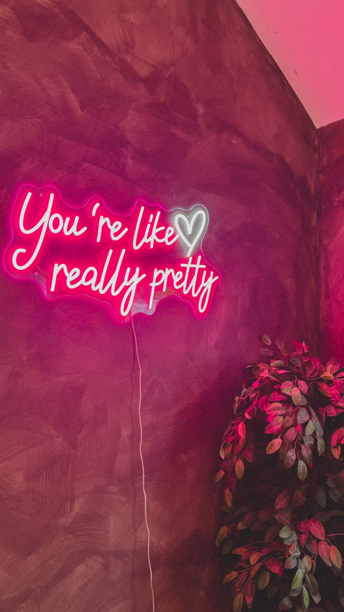 A pink neon sign glowing on a studio wall