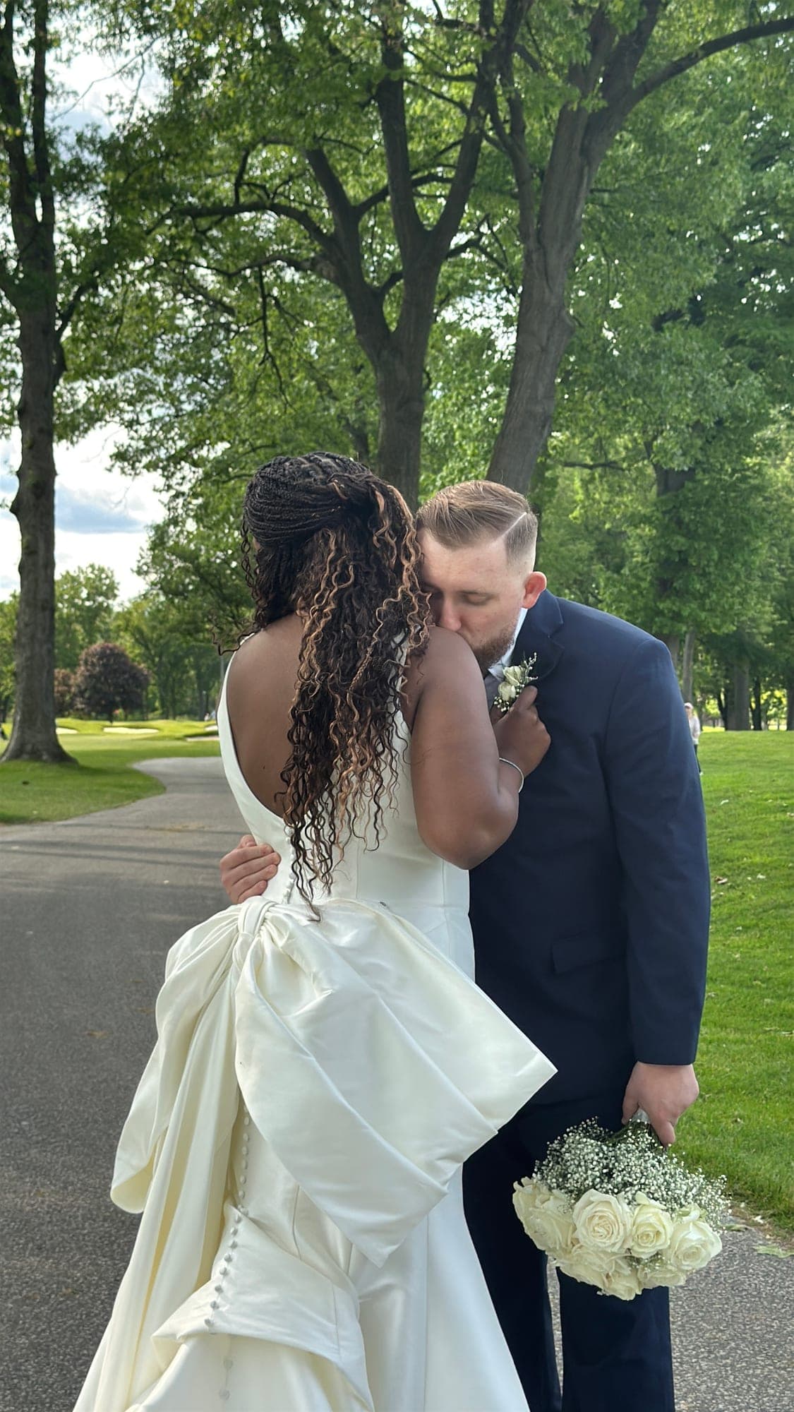 Brandon kissing Trenee on a tree-lined path