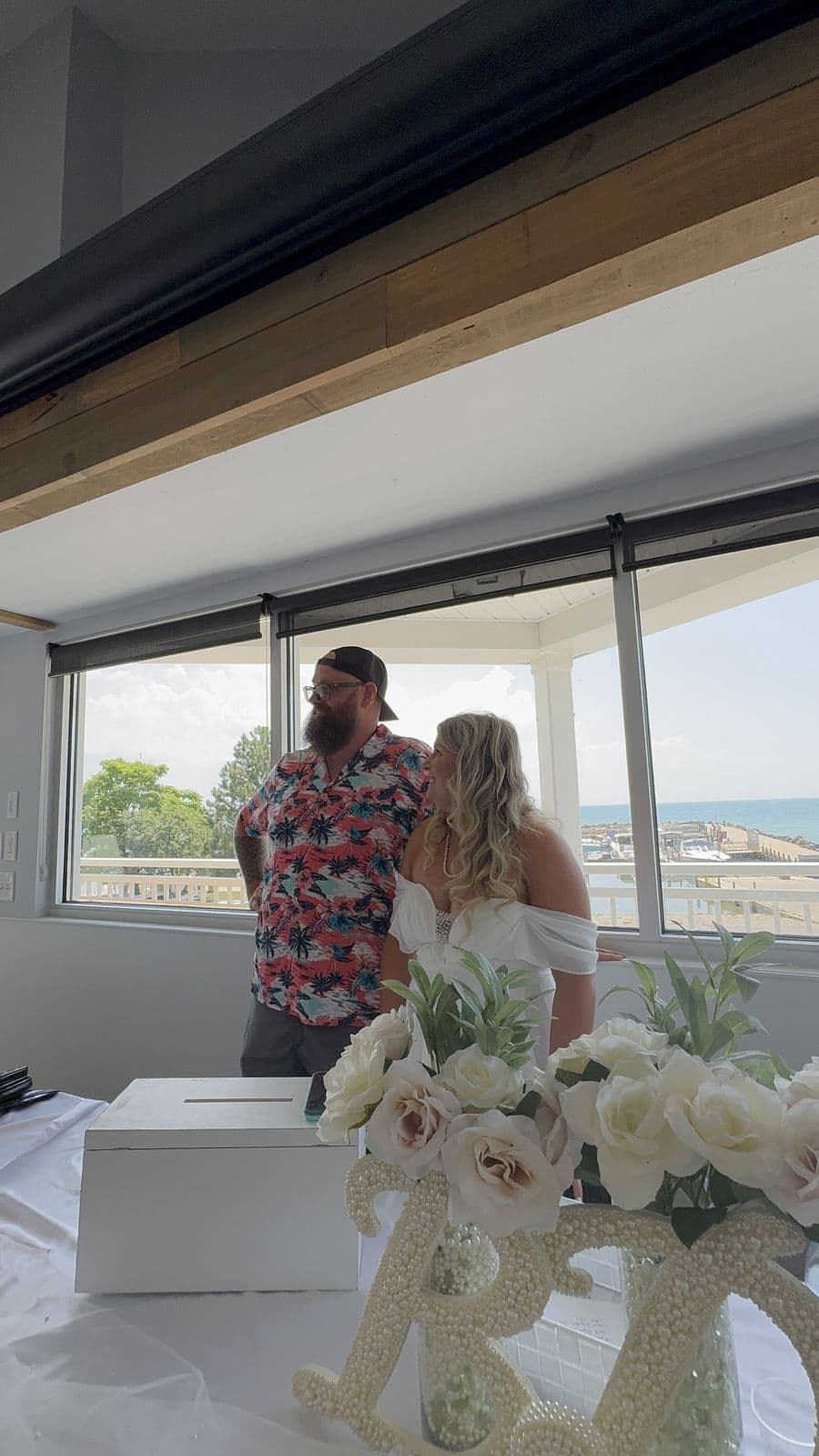 A couple greeting guests at a lakeside shower